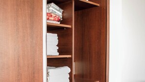 A wooden wardrobe with multiple shelves and drawers, containing folded towels and a folded blanket. - Apartamentos Los Asturianos.- Asturiano 1 (Mar del Plata)
