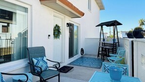 A patio with outdoor furniture, a door, and a small garden area.