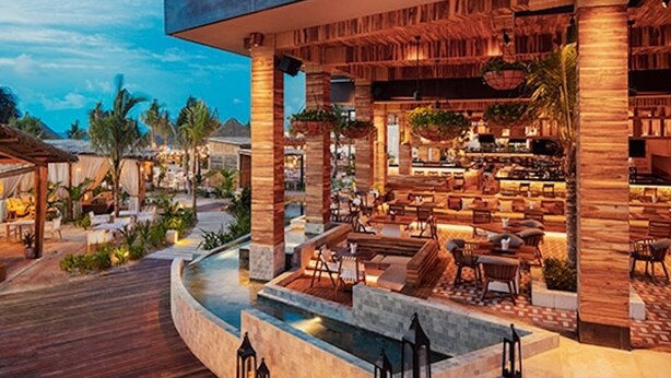 Un resort con piscina, zona de estar al aire libre y bar.