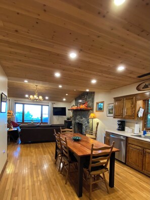 A wooden interior with a dining table, chairs, a fireplace, and a kitchen area. - Amazing view,sleeps 7 hot tub,Wi-Fi, game room,fire pit total privacy on 4 acres (Murphy)