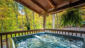 A hot tub under a wooden pergola with a view of a forest. - Luxury Cabin in beautiful Wears Valley (Sevierville)