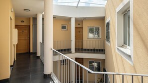 Un interior de varios niveles con una escalera central, techo de cristal y vistas al exterior.