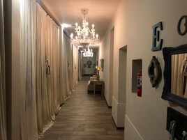 Un pasillo con una araña, un extintor y un espejo en la pared.