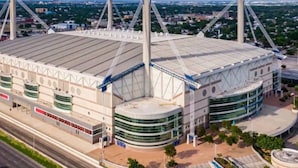 Un estadio con un amplio campo central, varios niveles de asientos y una estructura de puente destacada.