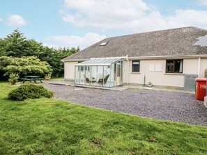 A house with a conservatory, a gravel driveway, and a picnic table. - LILLY'S BUNGALOW, pet friendly in Clonakilty, County Cork (Timoleague)