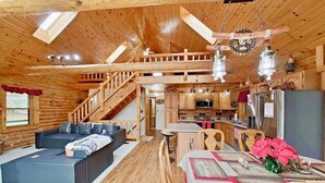L’intérieur d’une cabane en bois comprend une chambre à coucher située en mezzanine, un coin repas et une cuisine.
