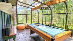 A pool table in a room with large windows, a wooden ceiling, and a view of a forest. - Lodge Off Main, Walk to Gondola! (Breckenridge)