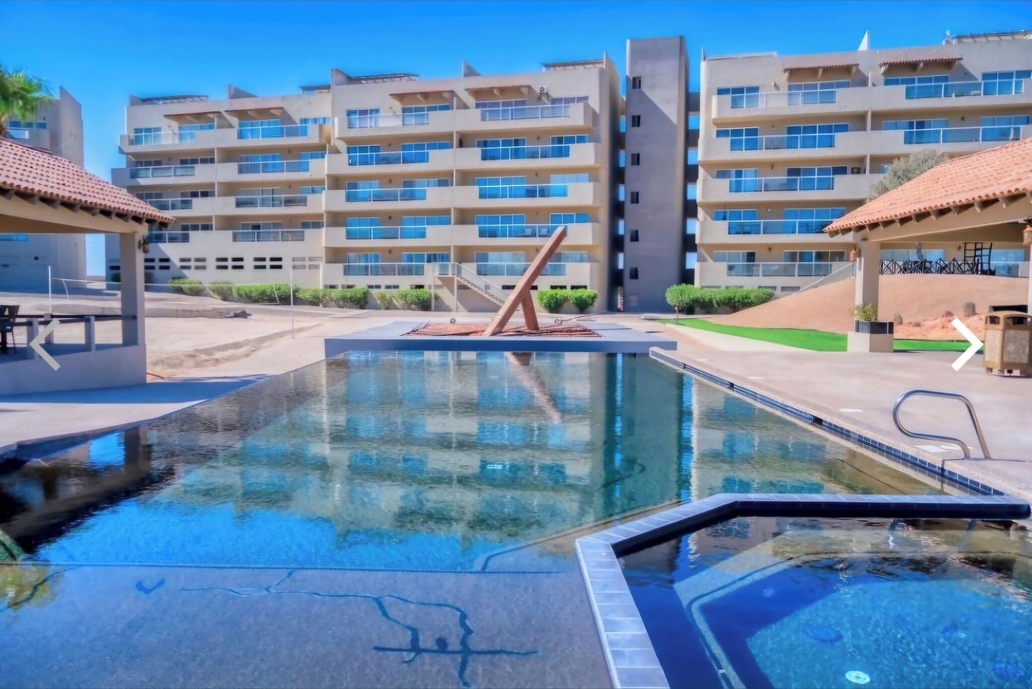 Una piscina dal design moderno, circondata da edifici a più piani con balconi.