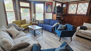 A living room with multiple sofas, a coffee table, and a television.