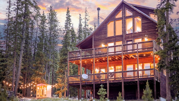 A wooden cabin with a balcony and multiple windows, surrounded by trees. - Epic Views + Stargazing Net • Hot Tub • Sauna • Luxury Vibes (Fairplay)