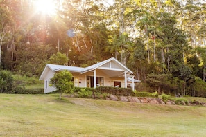 A house with a sloped roof, a covered porch, and a well-maintained lawn.
