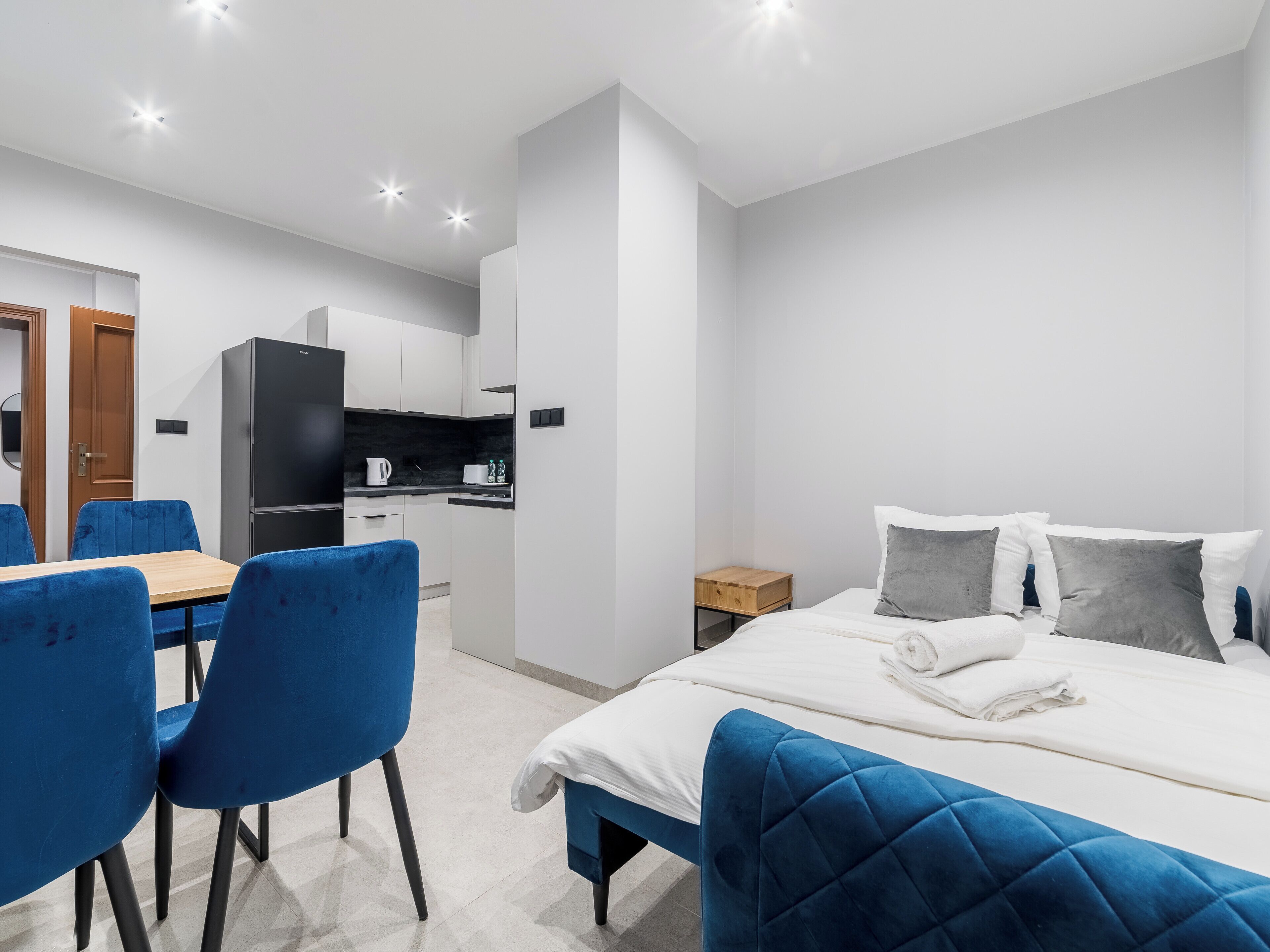 Une chambre d’hôtel moderne équipée d’un lit, d’un petit bureau et d’une kitchenette.
