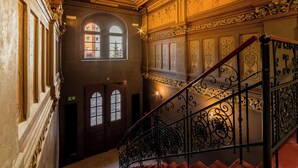 En imponerende trappe med detaljerede metalgelændere og udsigt over bygningens indre arkitektur.