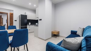 En moderne stue med en blå sofa og et spiseområde med blå stole.