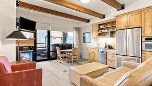 A modern living room with a sofa, a coffee table, and a fireplace. - Newpark 217 | Private Hot Tub | Kitchenette | Fireplace | Washer & Dryer | Balcony | Pool & Hot Tub (Park City)