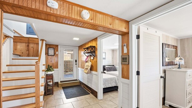 A hotel entrance with a wooden staircase, a reception desk, a bed, and a bathroom with a mirror. - Sandy Keys 1 *Pet Friendly*2min walk to beach! (Kill Devil Hills)