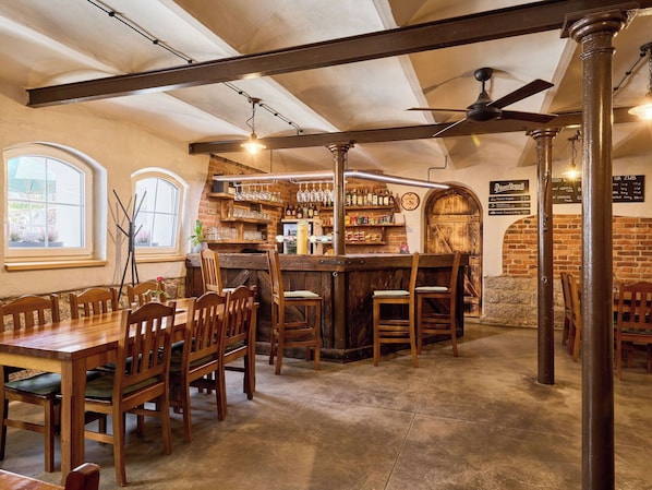 A bar area with wooden furniture, a brick wall, and a menu board.