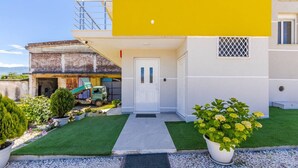 A two-story building with a yellow facade, a white door, and a small balcony. - Bliss Studio Free Parking Wifi (Lazarat)