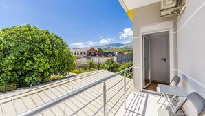 A balcony with a metal railing, a table, and two chairs. There is a door leading to an interior space. - Bliss Studio Free Parking Wifi (Lazarat)