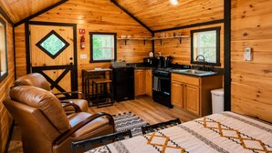 Ein gemütliches Blockhaus-Interieur mit Essbereich, Küche und einem Bett.