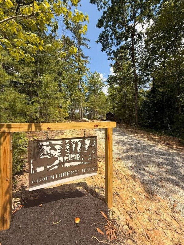 A sign with a silhouette of a moose and trees, labeled "Adventurers' Nook". - Adventurer’s Nook | Tiny Home w/ Hot Tub & Firepit (Campton)