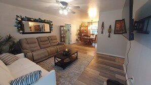 A living room with a sofa, coffee table, and a ceiling fan.