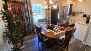 A dining area with a wooden table, chairs, and a chandelier.
