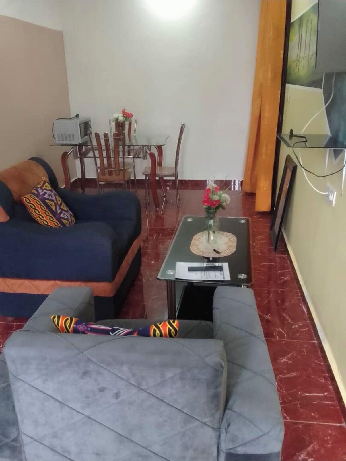 A living room with a sofa, a coffee table, and a dining area with chairs and a table.