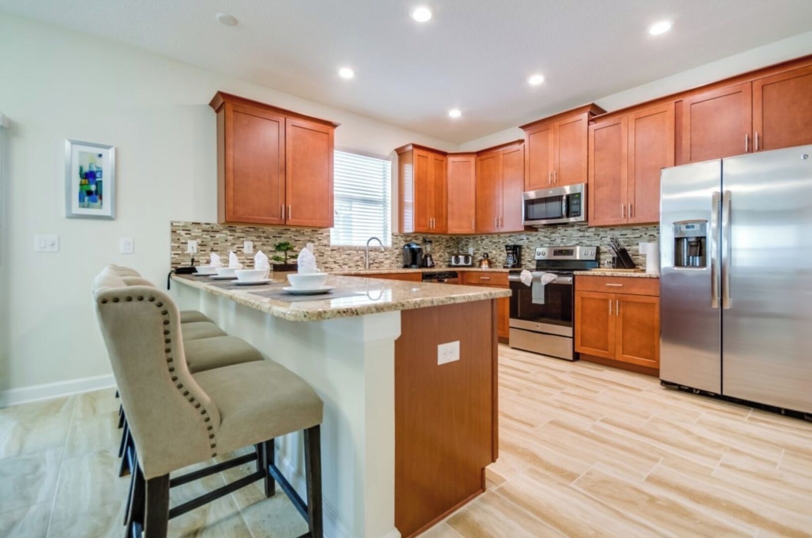 A modern kitchen with wooden cabinets, stainless steel appliances, and a granite countertop.