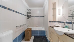 Un bagno con vasca, WC, lavandino e zona doccia.
