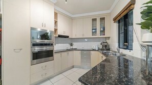 Una cucina con elettrodomestici in acciaio inossidabile, un piano di lavoro in granito e una finestra con vista.