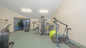 A gym with exercise equipment, a punching bag, and a large exercise ball.