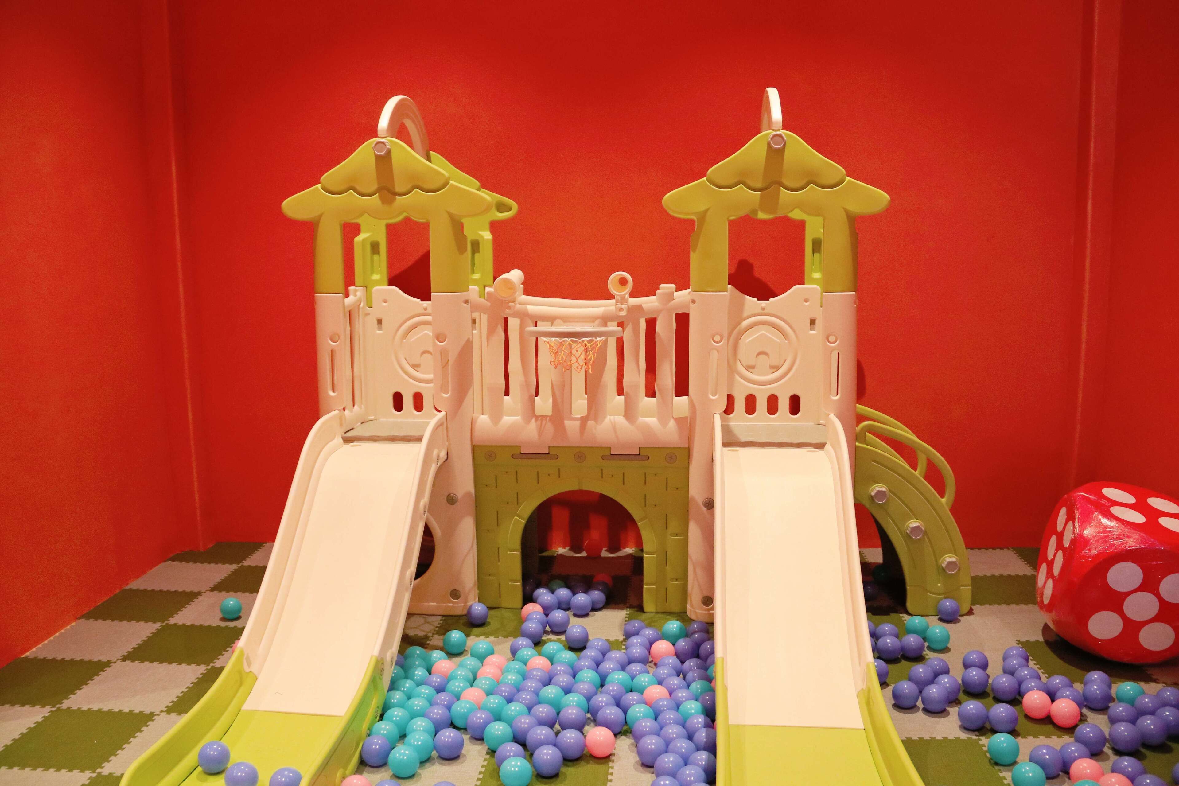 Un espace de jeux pour enfants avec un toboggan et une piscine à balles.