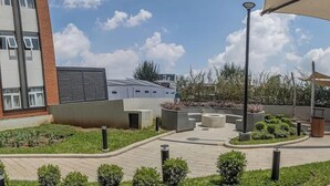 A courtyard with a seating area, a lamp post, and a building with a modern design. - Volcano Views Luxury w/ KING Bed & Free Facilities (Guate)