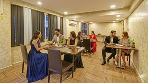 A conference room with a long table, multiple chairs, and a patterned carpet. - Fabhotel The Walnut (Pune)