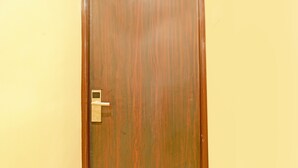A wooden door with a modern electronic lock.