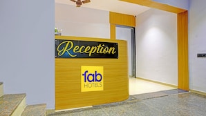 A reception desk with a sign reading "Reception" and "tob Hotels" on a wooden panel. - Fabhotel Nidhivan Palace (Surat)