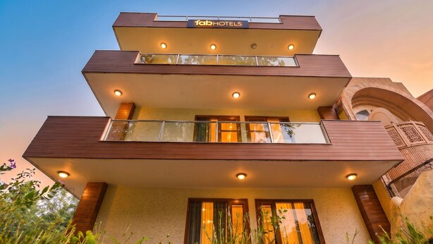 A multi-story hotel with a modern design, featuring balconies and a prominent signage for 'fab hotels.'