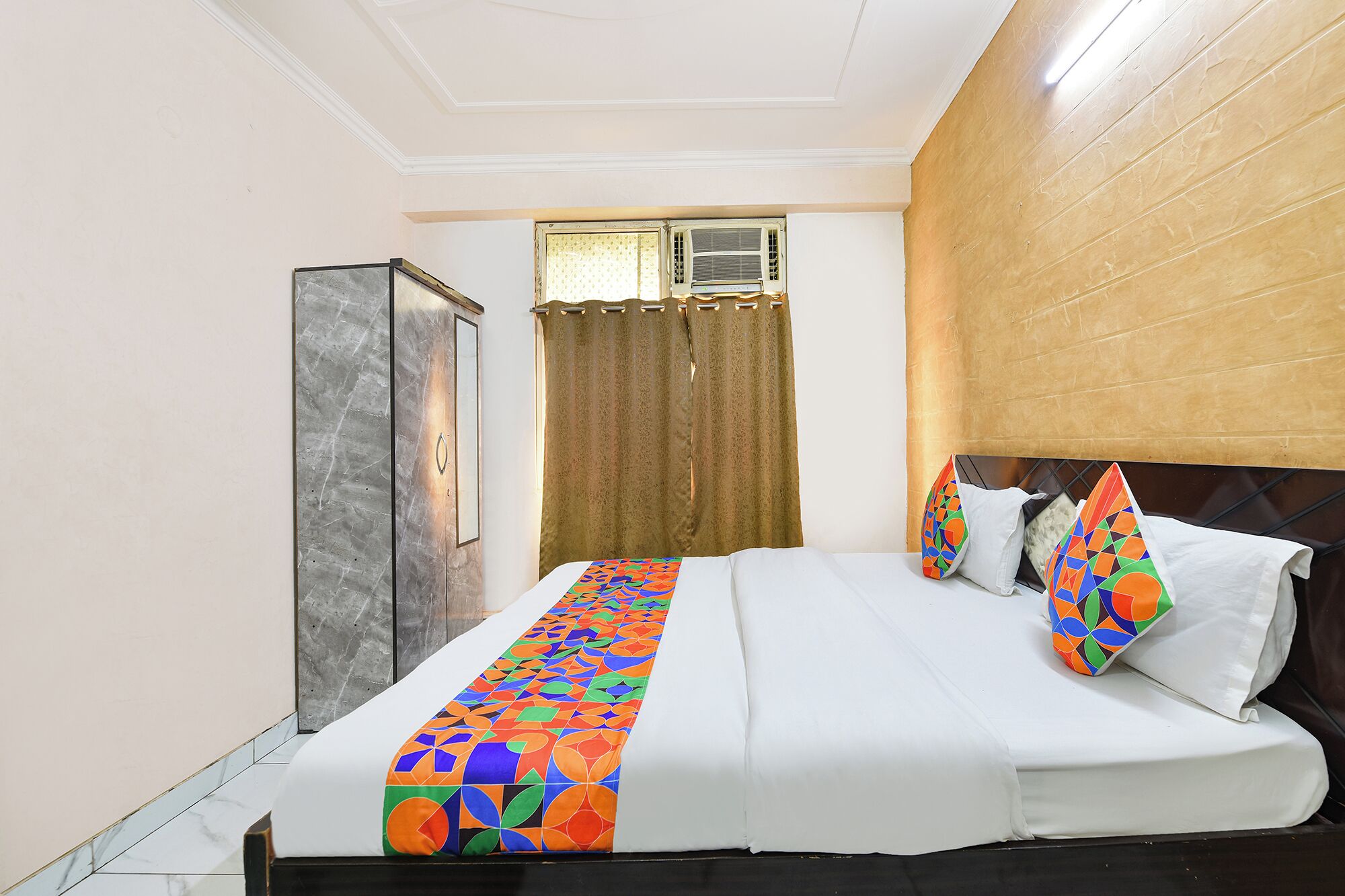 Quarto de hotel com uma cama, um guarda-roupa e ar condicionado.