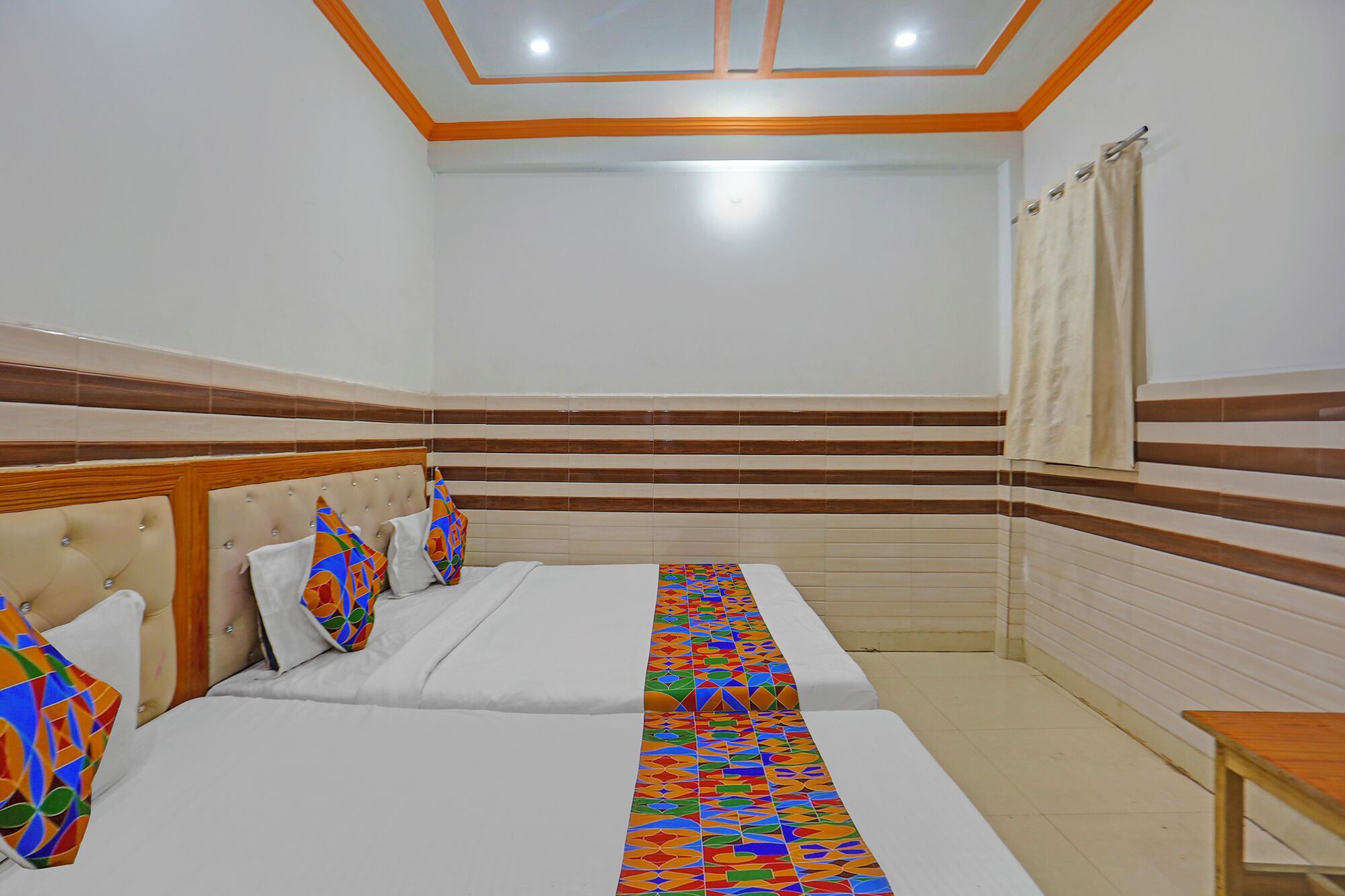 A hotel room with a bed, a window with curtains, and a wooden headboard.