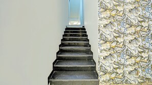 A staircase with a marble wall on one side and a plain wall on the other. - Fabhotel Starlight Inn (Ujjain)