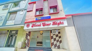 A hotel named 'Hotel Star Light' with a red and white facade, a visible entrance, and a sign for 'fabHOTELS' above. - Fabhotel Starlight Inn (Ujjain)