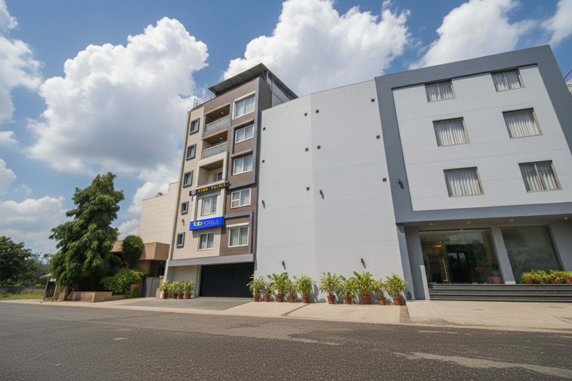 A modern multi-story hotel with a flat facade, balconies, and a visible entrance.