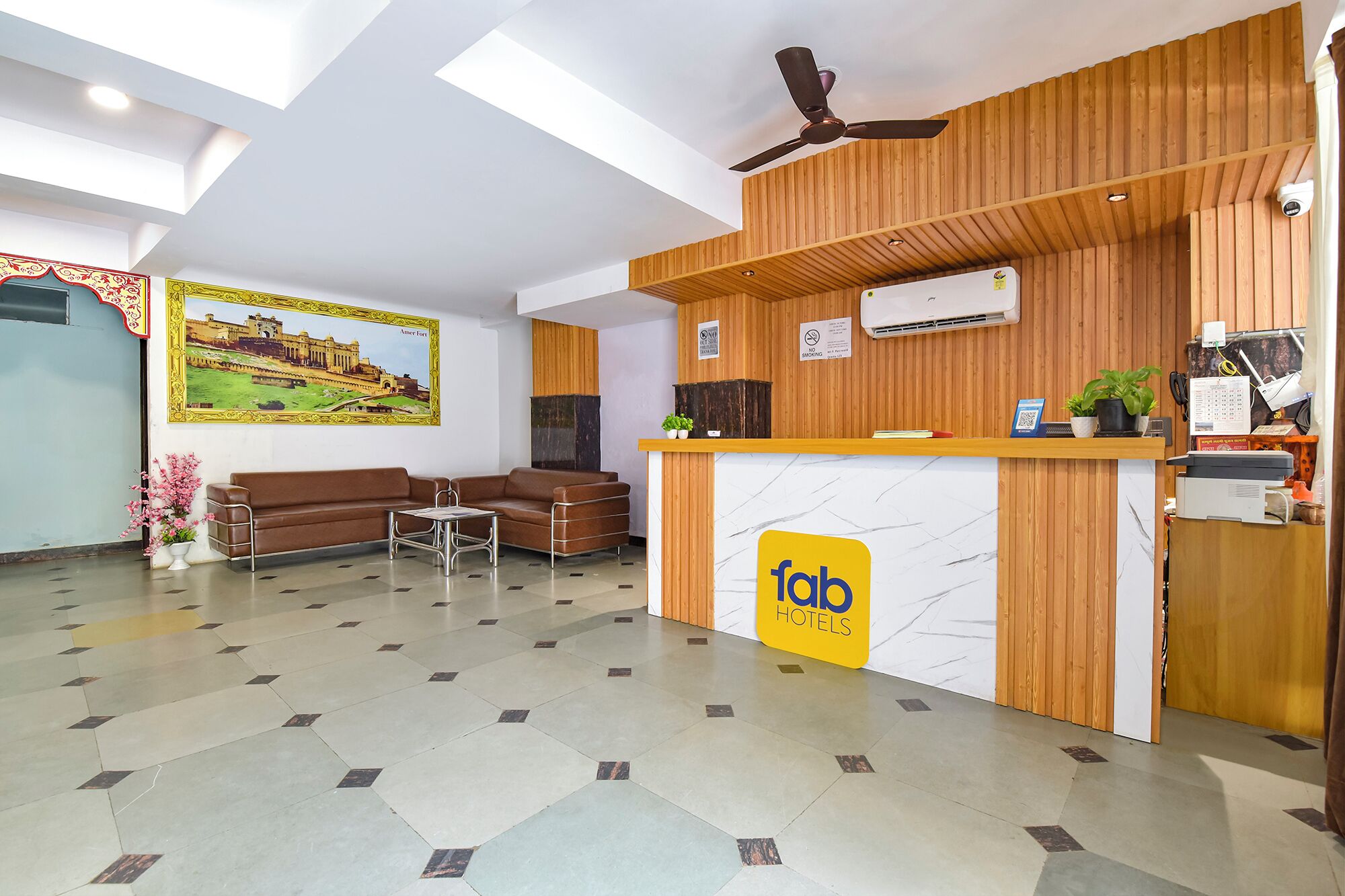 Een hotel receptie met een houten balie, een bank en een salontafel.