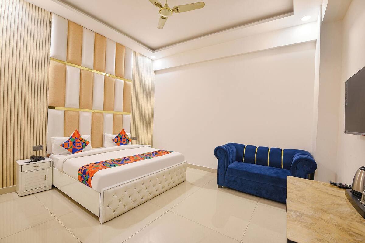 A modern bedroom with a bed, bedside table, and a blue sofa.
