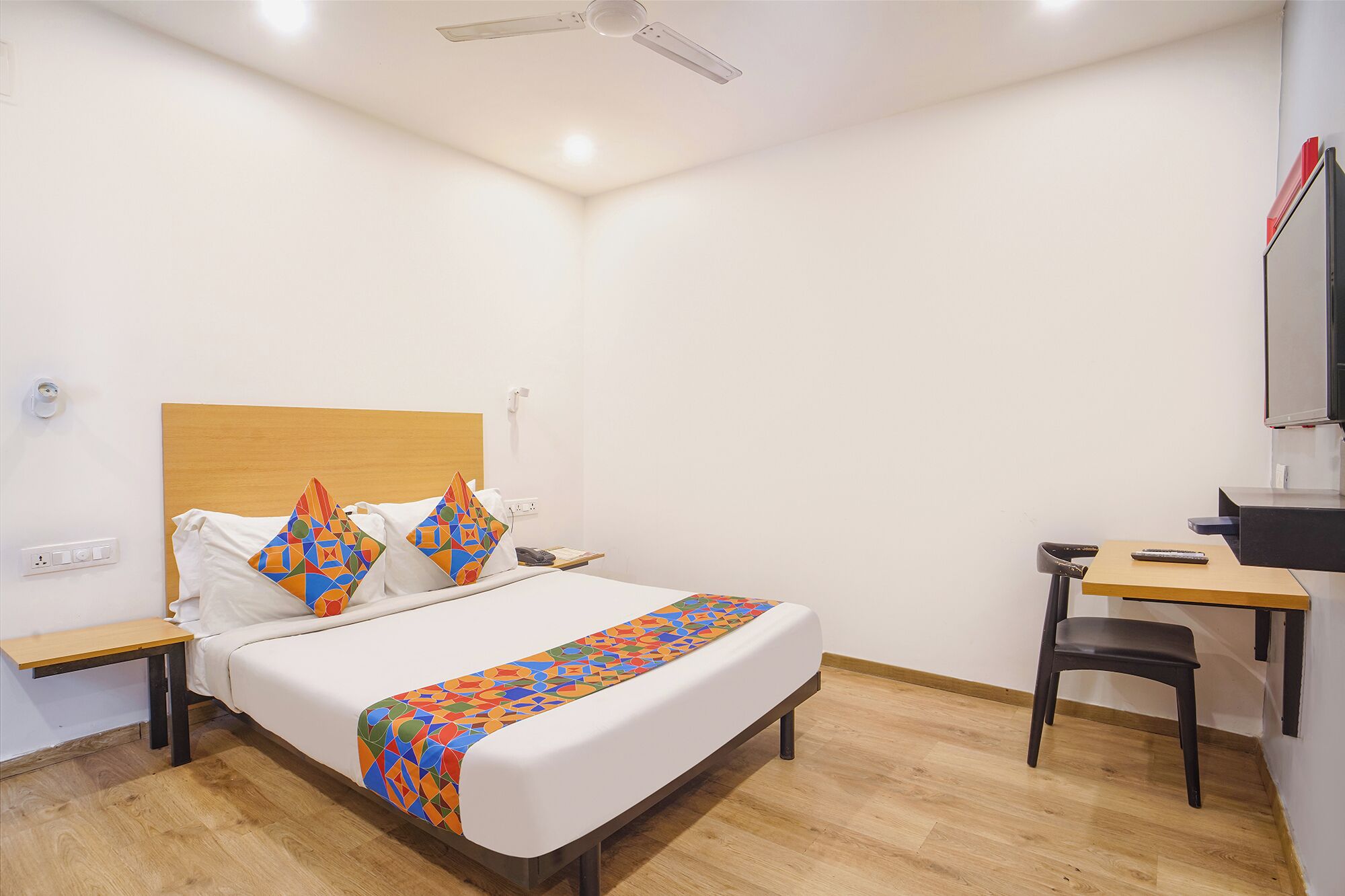 Una habitación de hotel con una cama, un escritorio y una silla.