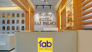 Una recepción con un cartel que indica 'BG Group Hotel Raj Palace' y 'Fab Hotels'.