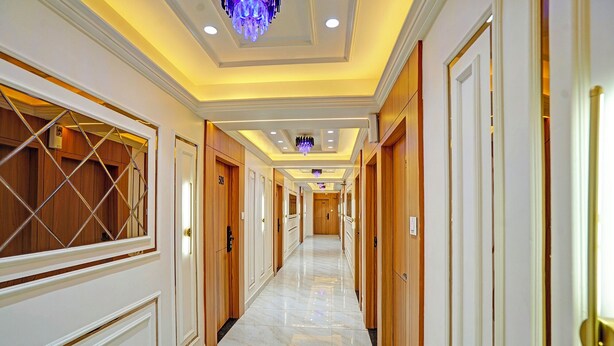 Un pasillo de hotel con puertas de madera, numeradas 509 y 505, y suelo de mármol.