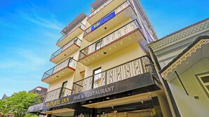 A multi-story building with balconies, a bar and restaurant on the ground floor, and a sign for 'Tranquil Inn'. - Fabhotel Tranquil Inn (Calangute)