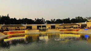 A well-lit outdoor area with a water feature, seating areas, and a covered walkway.